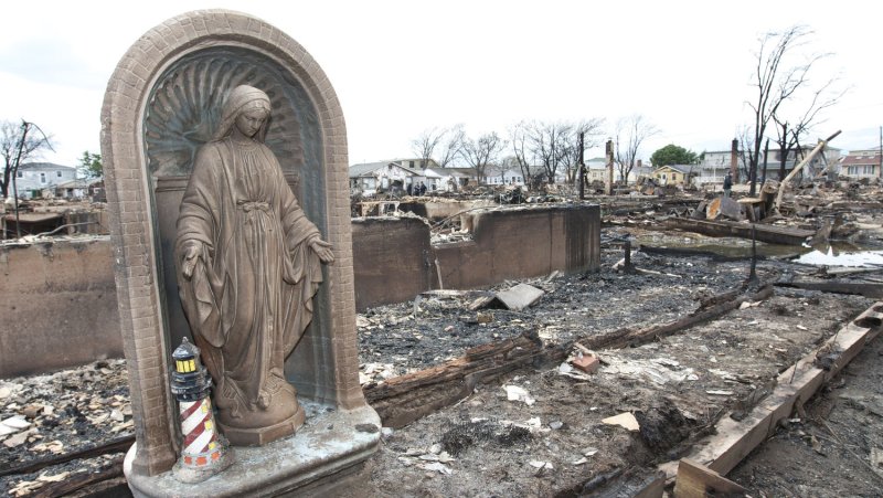 A statue of the Virgin Mary stands among the charred debris where eighty houses burned to the ground in the community of Breezy Point in the borough of Queens on October 31, 2012 in New York City. High winds brought on by Hurricane Sandy fueled the fire while high water made it difficult for firemen to contain the blaze. UPI /Monika Graff