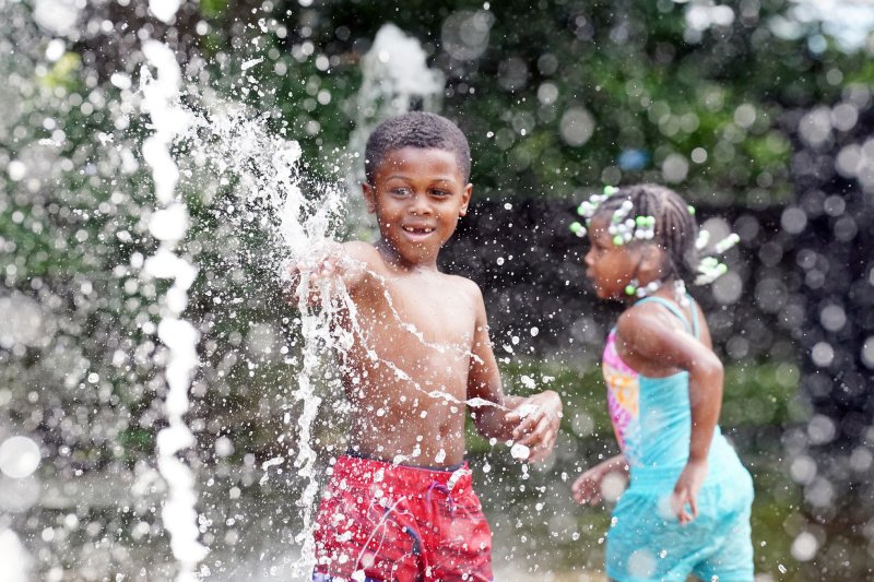 Tae Jones, 7, and his sister Riya, 4, beat the 100- degree heat in July in the jet sprays at the City Garden in St. Louis. High temperatures are expected to return to the region next week. File Photo by Bill Greenblatt/UPI | <a href="/News_Photos/lp/e490950101333e40ab87f722fdd25927/" target="_blank">License Photo</a>