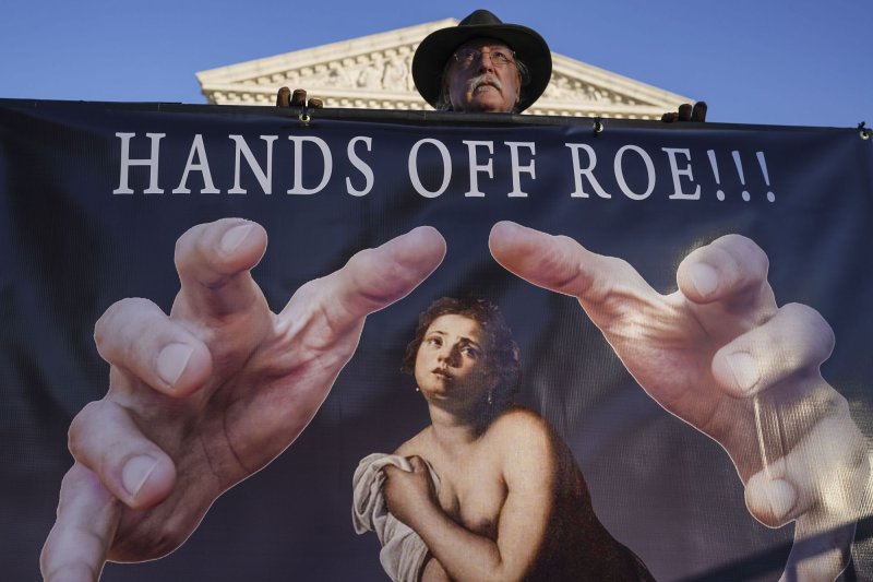 A man holds a pro-choice sign during a news conference at the Supreme Court in Washington on Tuesday.&nbsp; Photo Leigh Vogel/UPI