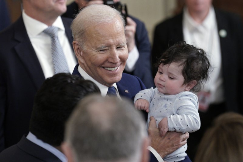 U.S. President Joe Biden holds 4-month-old Hodge, son of Congressman Jimmy Gomez, at an anniversary event for the Affordable Care Act in the East Room at the White House in Washington on Thursday. The president thanked lawmakers and advocates for leading the way for the act's approval 13 years ago. Photo by Yuri Gripas/UPI