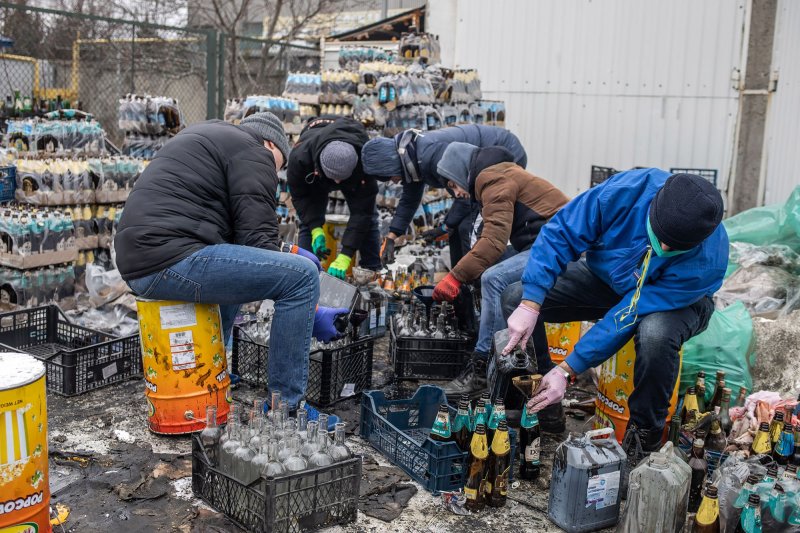 Ukrainians prepare Molotov cocktails outside their homes in Lviv in western Ukraine on Wednesday. Russian troops entered Ukraine on February 24, triggering a Ukrainian resistance and a series of announcements by Western countries to impose severe economic sanctions on Russia. Photo by Oleksandr Khomenko/UPI