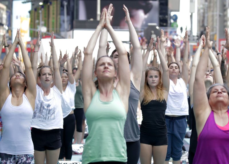 People participate in yoga classes in Times Square to celebrate the Summer Solstice on the first day of summer in New York City on Wednesday. Thousands of yogis will participate in eight yoga classes during the 15th annual Solstice in Times Square. Photo by John Angelillo/UPI