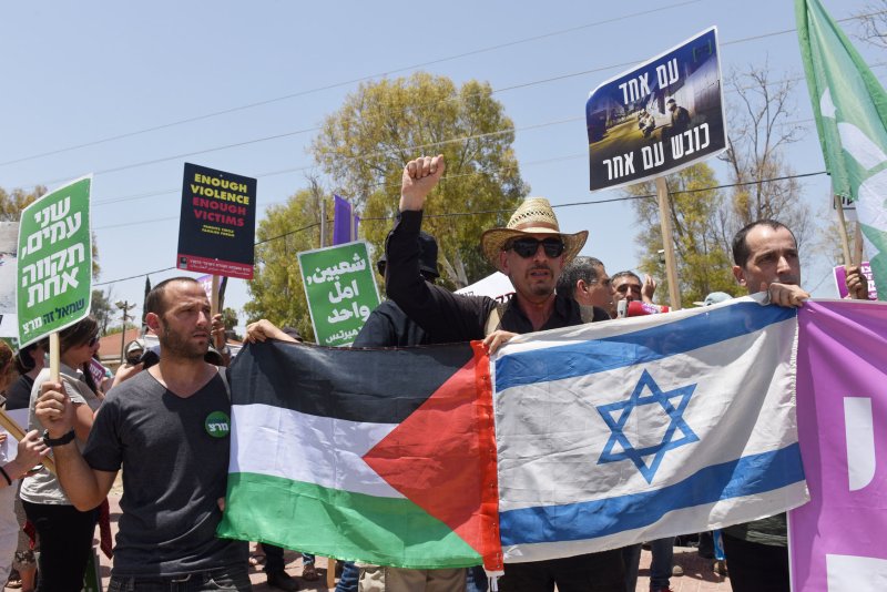 Israeli protesters hold signs calling on the government to stop violence against Palestinians on the Israel-Gaza border Friday. The U.N. Commissioner on Human Rights agreed to launch an investigation into Israel's response to deadly protests this week. Photo by Debbie Hill/UPI