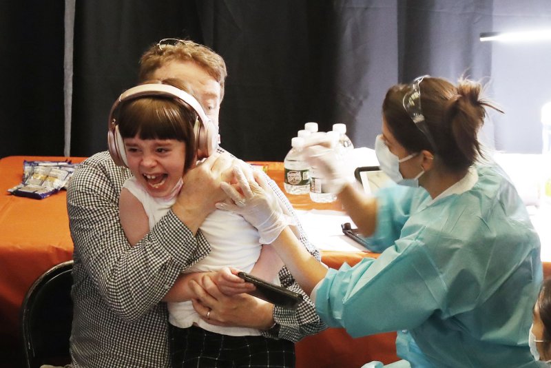 An 8-year-old girl gets a COVID-19 vaccine at the American Museum of Natural History in New York on Tuesday. Photo by John Angelillo/UPI