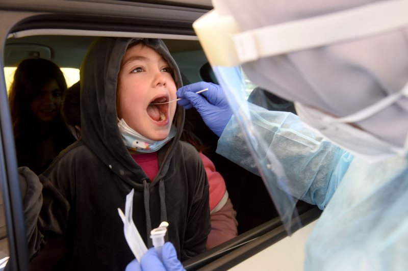 A medical worker administers a COVID-19 test to an Israeli boy at a Magen David Adom drive-through testing complex in Jerusalem on January 18, 2022. Photo by Debbie Hill/UPI
