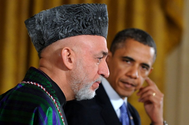 U.S. President Barack Obama adjusts his translation earpiece as he listens to Afghanistan President Hamid Karzai make a point during a joint press conference in the East Room of the White House in Washington, DC on January 11, 2013. (UPI/Pat Benic)