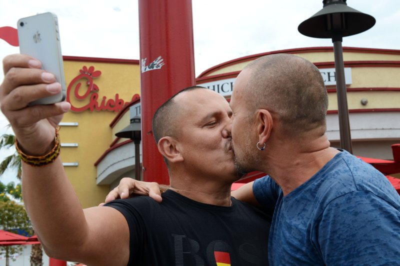 Same-sex couple Juan Rivera (L) and Eric Manriquez participate in a "kiss-in" outside a Chick-fil-A restaurant, in the Hollywood section of Los Angeles on August 3, 2012. Chick-Fil-A CEO Dan Cathy's recently admitted his public opposition of gay marriage was a 'mistake'. UPI/Jim Ruymen