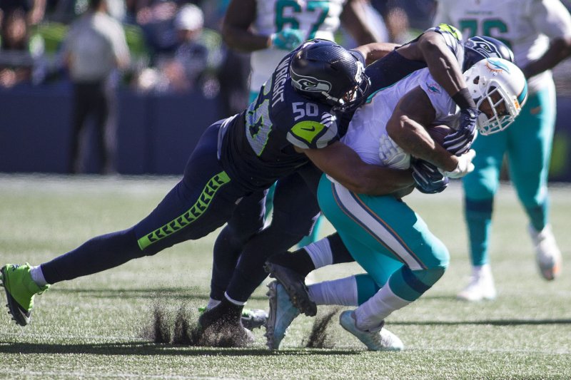 Seattle Seahawks outside linebacker K.J. Wright (50) defensive end Cliff Avril bring down former Miami Dolphins running back Arian Foster during the third quarter at CenturyLink Field in Seattle, Washington on September 11, 2016. Seahawks came from behind to beat the Dolphins 12-10. Photo by Jim Bryant/UPI