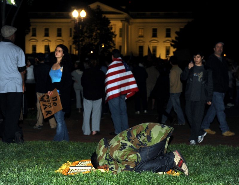 A young Muslim man prays as thousands celebrate the news that Al-Qaida terror leader Osama bin Laden is dead in front of the White House in Washington, DC, on May 2, 2011. At 11.35 tonight President Obama announced "the United States has conducted an operation that killed Osama bin Laden, the leader of al Qaeda, and a terrorist who’s responsible for the murder of thousands of innocent men, women, and children." UPI/Roger L. Wollenberg | <a href="/News_Photos/lp/a7489c90afd408b8e6b42a9c550dc84f/" target="_blank">License Photo</a>