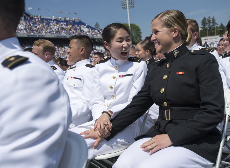 Graduating Midshipman Judith Cho (L) congratulates classmate Michaela Connally after she took the oath of office during the 2016 graduation and commissioning ceremony at the U.S. Naval Academy in Annapolis, Md., on May 27, 2016. On December 3, 2015, Defense Secretary Ashton Carter announced all combat roles in the U.S. armed forces would be opened to women. File Photo by Kevin Dietsch/UPI