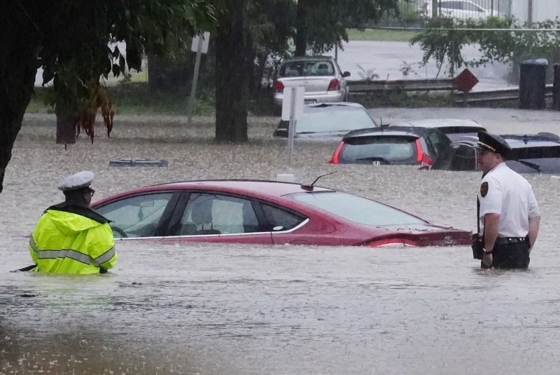 Police wade through flood waters looking for those in their cars. One fatality was reported after a driver was found in his car in 9 feet of water. Some areas in the St. Louis area received over 11 inches of water from heavy rains late Monday night and Tuesday morning. Photo by Bill Greenblatt/UPI