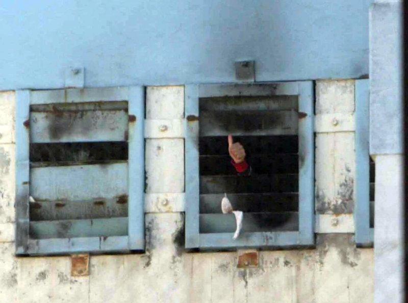 Prisoner signals "thumbs-up" after a fire spread through the San Miguel prison killing more than 80 south of Santiago, Chile on December 8, 2010. A fire was set during a riot in a prison that holds 1,900 but was built for 700. UPI/Sebastian Padilla