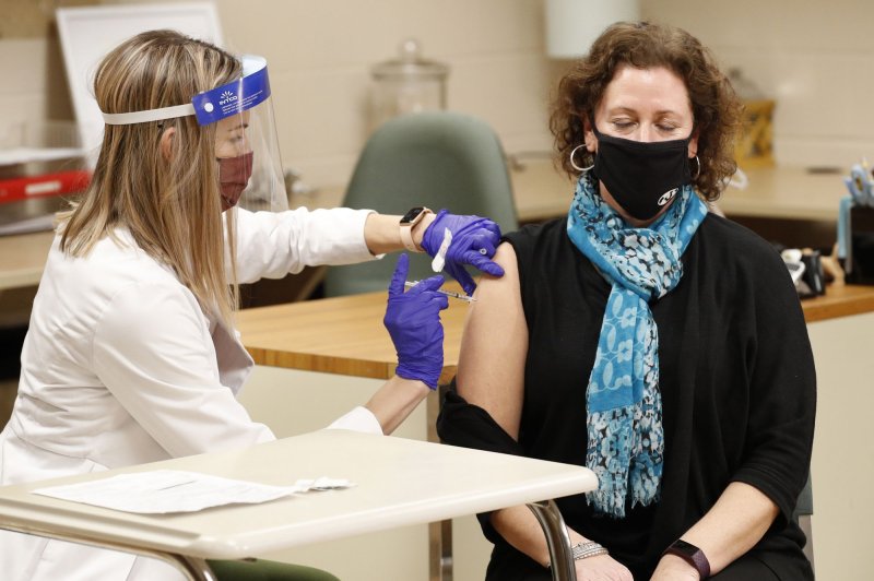 A health care worker administers the Pfizer COVID-19 vaccine to a middle school teacher in Medina, Ohio, on February 4. File Photo by Aaron Josefczyk/UPI