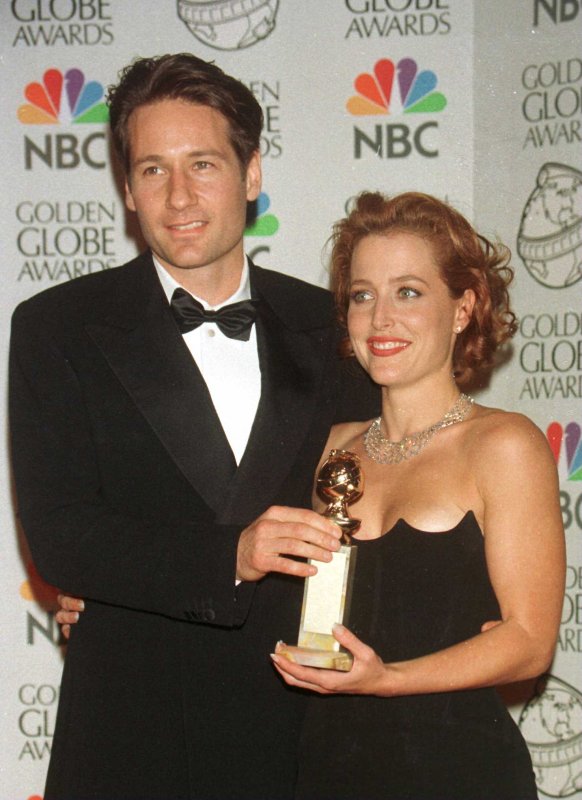Gillian Anderson (R) and David Duchovny with an award for "The X-Files" at the Golden Globe Awards on January 18, 1998. The co-stars discussed their onetime feud in a recent interview. File Photo by Jim Ruymen/UPI