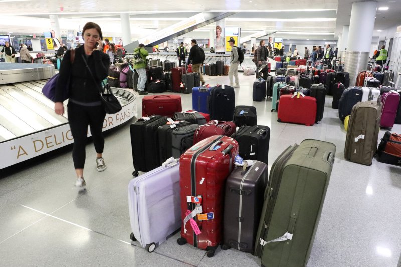 Travelers walk among sections of unclaimed luggage at baggage claim on a day where flights were canceled due to bad weather at JFK Airport in New York City on Friday. Photo by John Angelillo/UPI