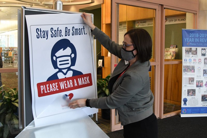 Workers at a public library in Plano, Texas. change out signs requiring a mask to enter on March 9 in preparation for changes in the state's mask mandate made by Gov. Greg Abbott. File Photo by Ian Halperin/UPI | <a href="/News_Photos/lp/15c4125d5ddc4fb99735c82e0bce1ca2/" target="_blank">License Photo</a>