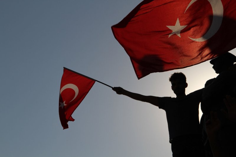 A Turkish citizen holds a national flag during a demonstration in July. Tuesday, a town in southeast Turkey was evacuated after it came under attack from Islamic State militants, officials said, as Turkish forces in the area prepared to launch an offensive to take control of a militant stronghold nearby. Photo by Hanna Noori/ UPI | <a href="/News_Photos/lp/f4ee7704fcda0e89610923812b9ef890/" target="_blank">License Photo</a>