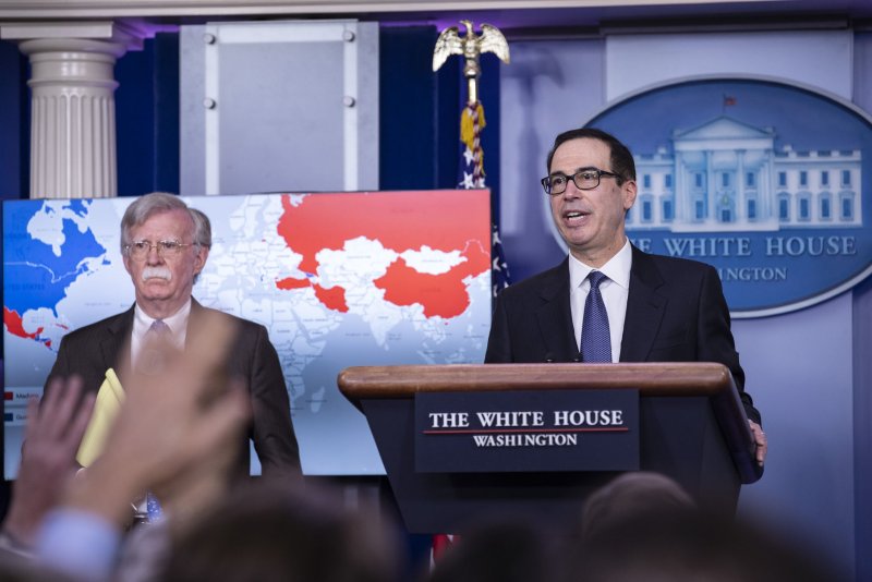 Treasury Secretary Steven Mnuchin (R) takes questions from reporters at the White House as national security adviser John Bolton stands by. Photo by Alex Edelman/UPI