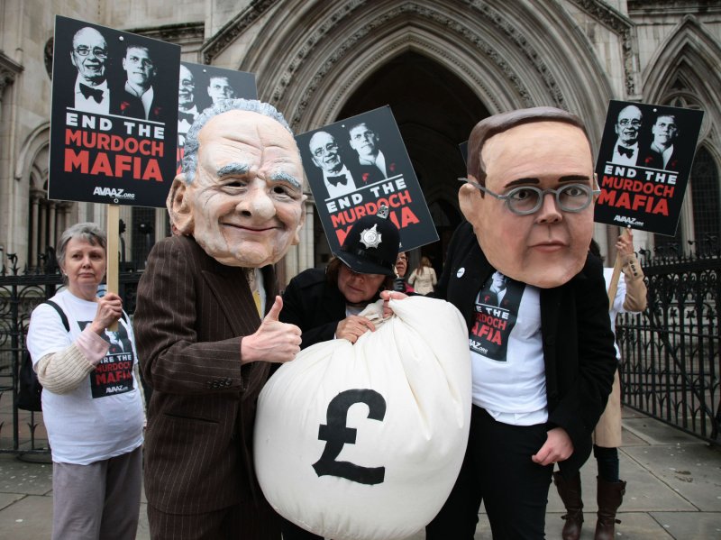 Protesters from the campaign group "Avaaz" demonstrate outside the High Court with large James and Rupert Murdoch masks as former News International Chairman James Murdoch gives evidence to the Leveson Inquiry in London on Tuesday April 24 2012.The Leveson Inquiry is currently concentrating on the owners of various media groups. UPI/Hugo Philpott | <a href="/News_Photos/lp/2449e5c9378a376b489f148b9d7eac87/" target="_blank">License Photo</a>
