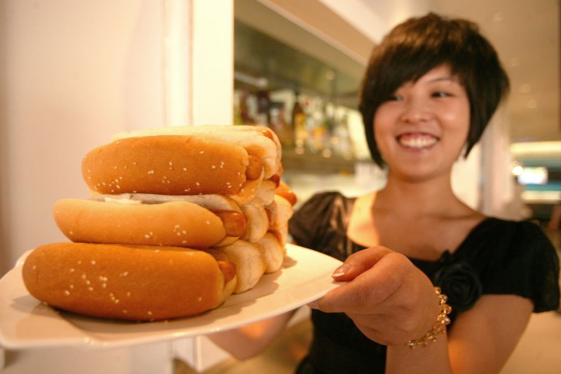 A server at a Beijing restaurant prepares hot dogs for an eating competition July 11, 2009. The National Hot Dog and Sausage Council in the United States announced this week that it does not consider hot dogs to be sandwiches. File Photo by Stephen Shaver/UPI | <a href="/News_Photos/lp/135467a50f47c338c522cd0b927f647e/" target="_blank">License Photo</a>