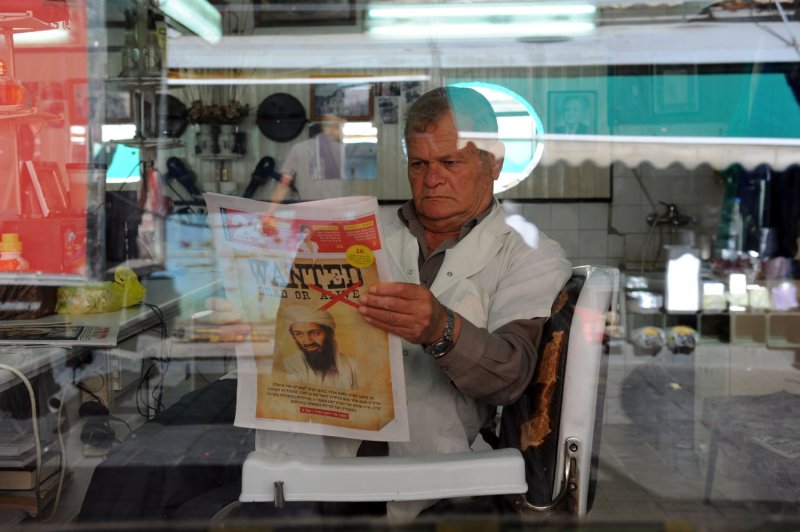 An Israeli barber reads a Hebrew newspaper in the Mahane Yehuda Market in Jerusalem with headlines announcing the killing of Osama bin Laden by U.S. special forces in Pakistan, May 3, 2011. UPI/Debbie Hill
