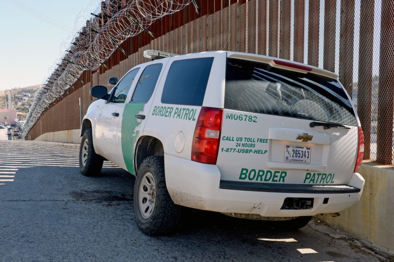 A United States Border Patrol truck sits in the shadow of the border fence which is adorned with barbed wire on it's top in Nogales, Arizona. Photo by Art Foxall/UPI