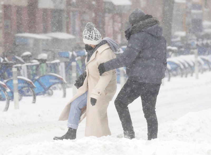 Pedestrians struggle to step through accumulated snow on 1st Avenue as a Nor'easter with blizzard-like conditions hits the east coast in New York City on Saturday. Photo by John Angelillo/UPI
