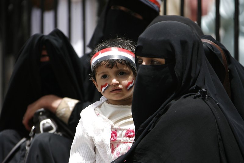 Yemeni An anti-government protester carries her child with the colors of the national flag painted on his face during a demonstration demanding the resignation of Yemeni President Ali Abdullah Saleh. in Sanaa on April 5, 2011, as two dissident soldiers and three other people were killed in a firefight between troops and tribesmen close to President Ali Abdullah Saleh. Five people were shot dead and four wounded in the clash near a square where anti-regime protesters have been staging a sit-in for the past two months. UPI\Mohammad Abdullah