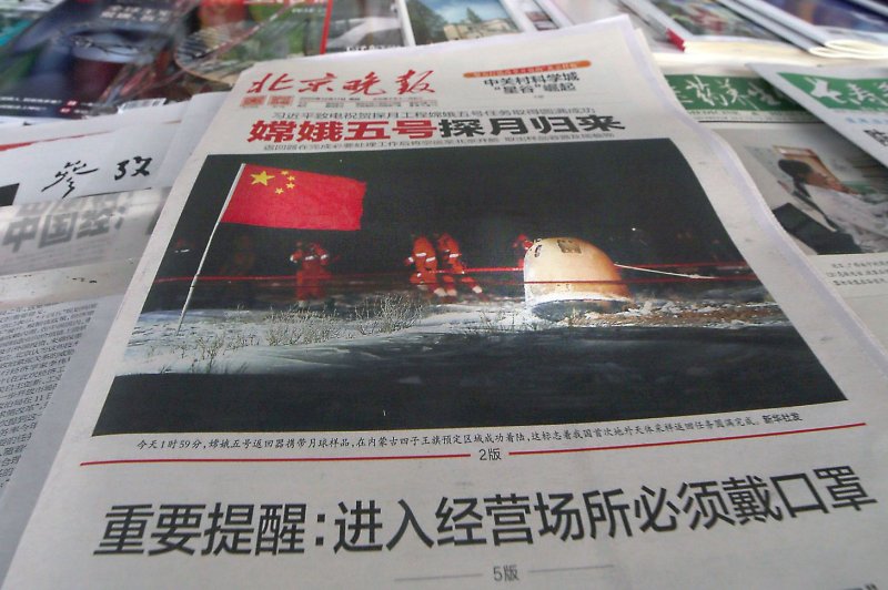 A Chinese newspaper reports on the successful landing of the Chang'e-5 lunar probe, at a news kiosk in Beijing, China, on December 17, 2020. File Photo by Stephen Shaver/UPI