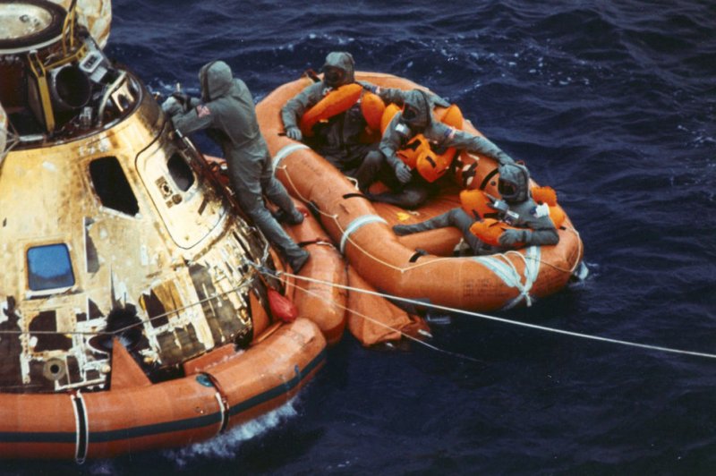 Pararescueman Lt. Clancy Hatleberg closes the Apollo 11 spacecraft hatch as astronauts Neil Armstrong, Michael Collins, and Buzz Aldrin, Jr. await a helicopter pickup from their life raft after they splashed down 900 miles southwest of Hawaii on July 24, 1969. File Photo courtesy NASA | <a href="/News_Photos/lp/8946b1a943b062fcc725242b20b8b6bd/" target="_blank">License Photo</a>