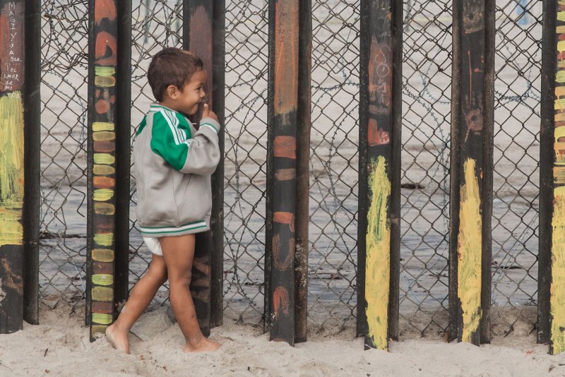 A young child looks through the border fence into the United States at Playas de Tijuana in Tijuana, Mexico, on November 28, 2018. File Photo by Ariana Drehsler/UPI