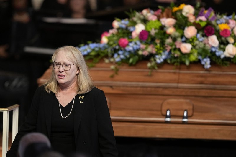 Amy Carter walks past her mother's casket after speaking at a tribute service for former first lady Rosalynn Carter at Glenn Memorial Church at Emory University on Tuesday in Atlanta. Pool Photo by Brynn Anderson/UPI