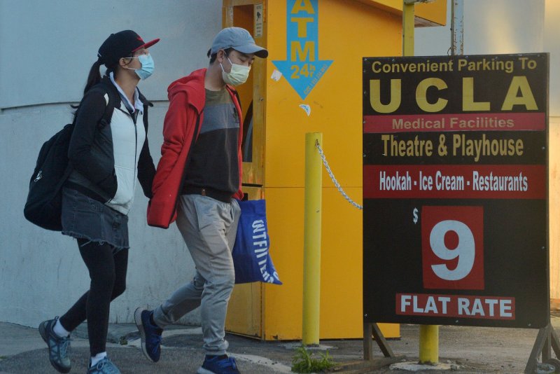 A couple wearing protective masks walk to their car near the UCLA campus in Los Angeles on Monday, March 30, 2020. Photo by Jim Ruymen/UPI