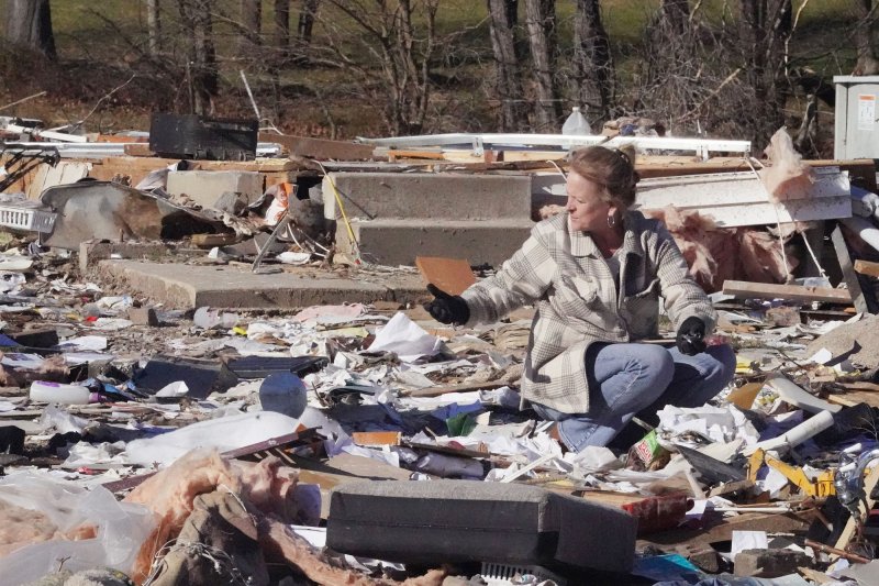 Volunteer Susan O'Toole looks through the belongings of Marcia and Rich Vance after their house was destroyed by a powerful tornado in Defiance, Mo., on December 12. Photo by Bill Greenblatt/UPI