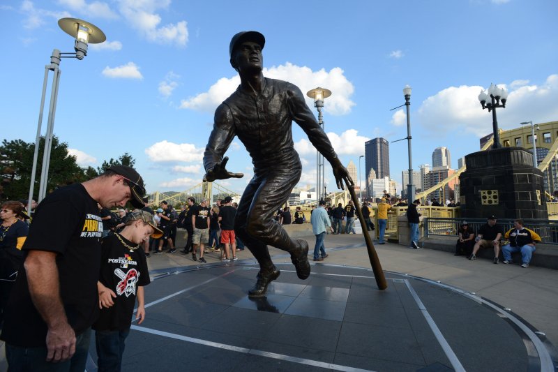 Pittsburgh Pirates fans look at the engravings at the Roberto Clemente statue next to the center field gate at PNC Park in Pittsburgh on October 1, 2013. On December 31, 1973, Pittsburgh Pirates great Roberto Clemente and died in a plane crash en route to deliver supplies to earthquake-stricken Nicaragua. File Photo by Pat Benic/UPI