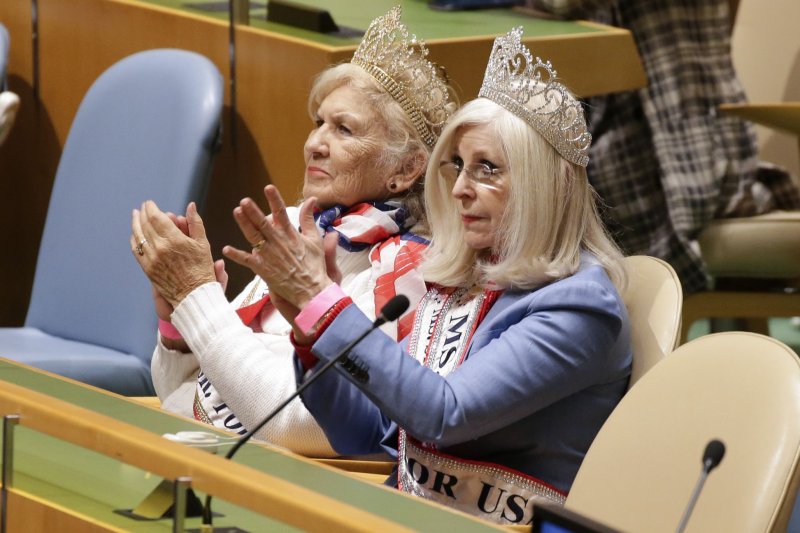 Two women wearing beauty pageant sash and head crowns applaud while they listen to speakers at the United Nations Observance of International Women's Day 2020 at U.N. headquarters in New York City on March 6. File Photo by John Angelillo/UPI | <a href="/News_Photos/lp/90252951bfbf92fc9c3de32049b31ae3/" target="_blank">License Photo</a>