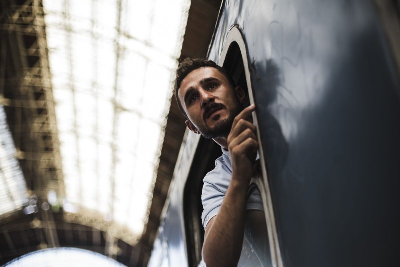 Syrian migrant looks out a window of a commercial train heading towards Vienna in the Keleti train station in Budapest, Hungary on September 6, 2015. Photo by Achilleas Zavallis/UPI
