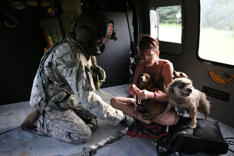 Sgt. Aaron Aldrige, Company G, 2-104th Aviation Battalion, helps calm a rescued a woman and her dogs after picking her up from a flooded area, on Thursday in Orange, Texas, following Hurricane Harvey. Photo by Anna Pongo/Nebraska National Guard/UPI | <a href="/News_Photos/lp/e94f5ddccd276094f46fc904320f24d5/" target="_blank">License Photo</a>