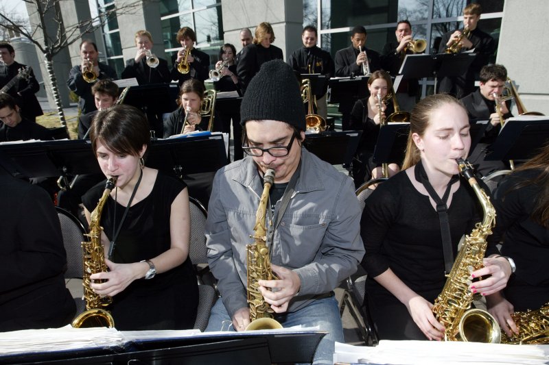 Julio Monterrey (C), saxophonist with the Maynard Ferguson Band, joins students Drew Lefklwith (L) and Berkley Adrio of the Clayton High School Jazz Band during the opening of the new Finale Music and Dining club in Clayton, Mo., in March 2005. Photo by Bill Greenblatt/UPI
