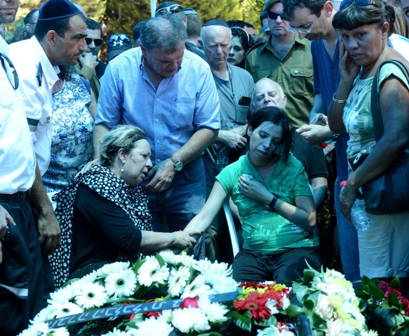 Sharona Baror (L) mother of slain Israeli soldier Major Tsafrir Baror, 32, comforts his wife, Sivon during his military funeral in the Holon cemetery, Israel, July 21, 2014. Baror, an officer in the Golan Brigade,was killed by Palestinian militants in Gaza. He leaves behind a wife, Sivon, who is eight months pregnant and a year old daughter. The Israel Defense Force says it has lost 18 soldiers, while more than 508 Palestinians have been killed in the 14 day battle. UPI/Debbie Hill