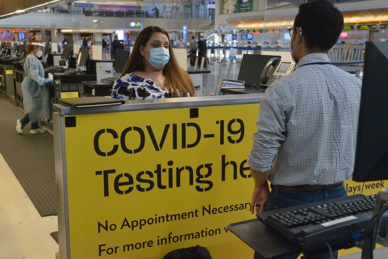 Nurse personnel process a traveler for the coronavirus test in the Tom Bradley International Terminal at LAX in November. White House officials on Friday said the CDC will lift coronavirus testing requirements for people flying into the United States. File Photo by Jim Ruymen/UPI