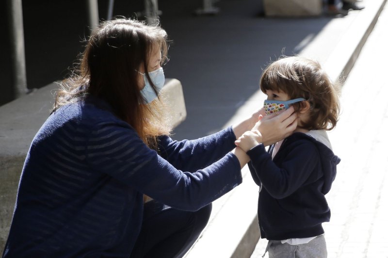 A woman helps a child with adjusting a face mask in New York City on September 21, 2020. File Photo by John Angelillo/UPI | <a href="/News_Photos/lp/6cdef3154e0ac257a40fcee3c269d8f9/" target="_blank">License Photo</a>