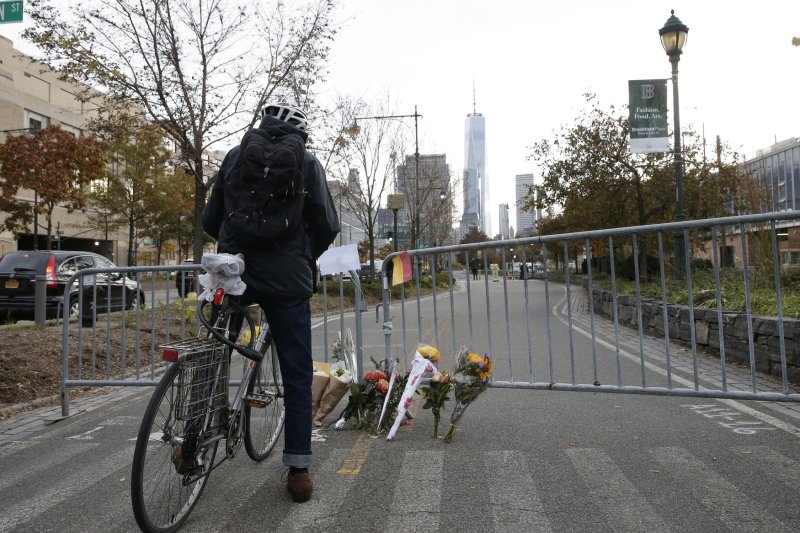 A man on a bicycle stops at a memorial of flowers near a bicycle path in Lower Manhattan on Wednesday where eight people died after being struck by a truck Tuesday. Photo by John Angelillo/UPI | <a href="/News_Photos/lp/f33250297d70ff3feb869cd8f9032945/" target="_blank">License Photo</a>