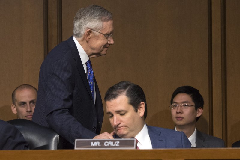 Senate Majority Leader Harry Reid (D-NV) places his hand on Sen. Ted Cruz's (R-TX) shoulder. UPI/Kevin Dietsch