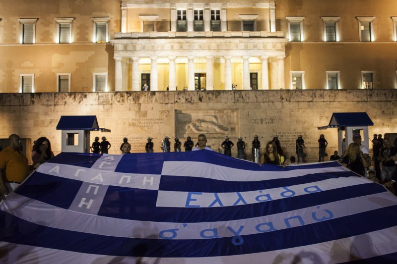 Greek citizens protest against the new package of austerity measures while lawmakers inside the parliament vote for the package to remain with the euro, in Athens, Greece on July 15, 2015. File Photo by Dimitris Michalakis/UPI