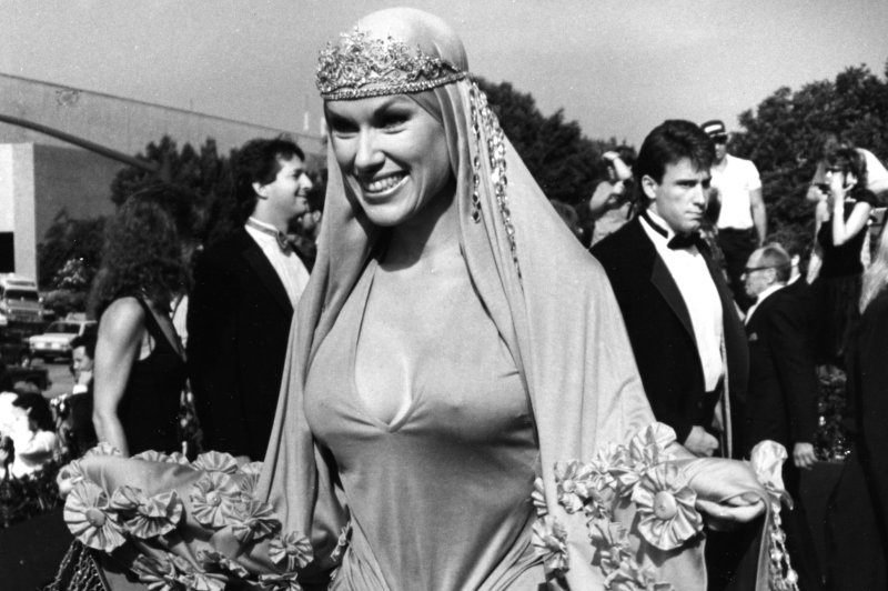 Jean Kasem, the wife of announcer Casey Kasem, shows off her elaborate gown as she arrives at the Emmy Awards show on August 28, 1988 in Pasadena, CA. (File/UPI/Glenn Waggner) | <a href="/News_Photos/lp/ca855ce4a549c063677163c14a2ef3f9/" target="_blank">License Photo</a>
