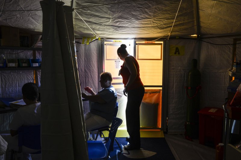 A ward clerk at Pavia Arecibo Hospital in Puerto Rico exits a medical tent on October 4. Puerto Rico Gov. Ricardo Rosello says he hopes to have 95 percent of the island's power grid working by Dec. 15. Photo by Master Sgt. Joshua DeMotts/U.S. Air Force/UPI