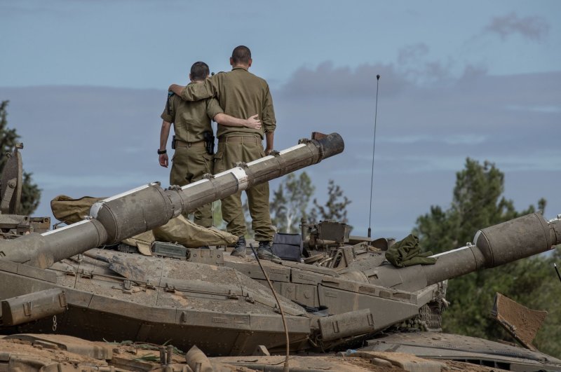 Israeli soldiers stand on a Merkava tank undergoing maintenance in a staging are along the Gaza Strip border on Tuesday during a pause in fighting. Photo by Jim Hollander/UPI