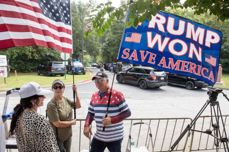 Supporters of former President Donald Trump hold flags outside the Fulton County Jail in Atlanta on August 24 before Trump surrendered on criminal charnges. Photo by Anthony Stalcup/UPI