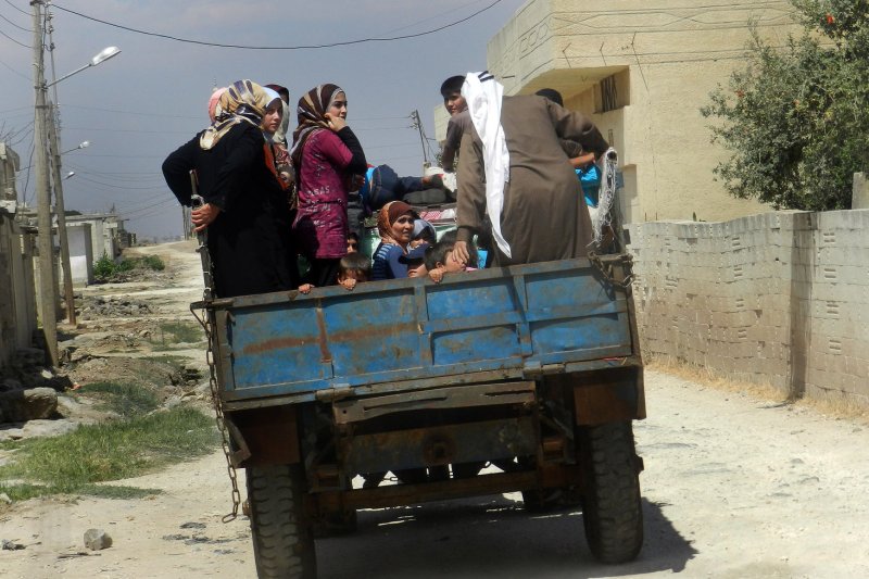 Syrian civilians flee in a vehicle at Houla near Homs in 2012 after government forces shelled a number of areas in northern Syria targeting rebel strongholds. UPI File Photo